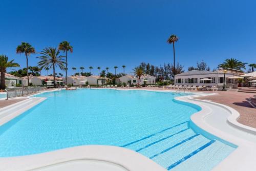 a swimming pool at a resort with palm trees at Campo Golf 68 by VillaGranCanaria in Las Palmas de Gran Canaria