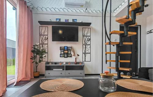 Il comprend un salon doté d'une télévision et d'une table avec des chaises. dans l'établissement 2 Bedroom Gorgeous Home In Wytowno - Ppl971, à Wytowno