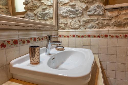 a bathroom with a white sink and a mirror at Ξενώνας Πελασγός in Sparti