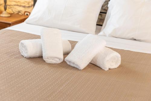 a group of four rolled towels on a bed at Ξενώνας Πελασγός in Sparti