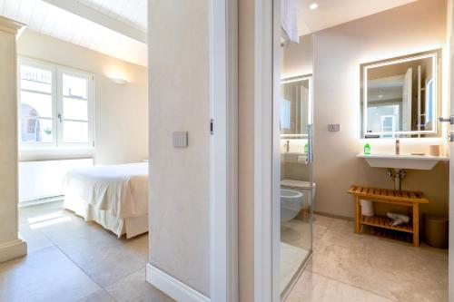 a bathroom with a sink and a bed in a room at Dimora Sella - Villa Ginevra in Alghero
