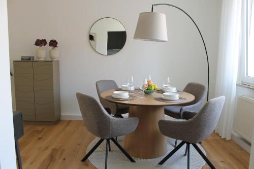 a dining room table with chairs and a mirror at Schöner Wohnen mit Balkon im Herzen der Stadt 4 Personen in Paderborn
