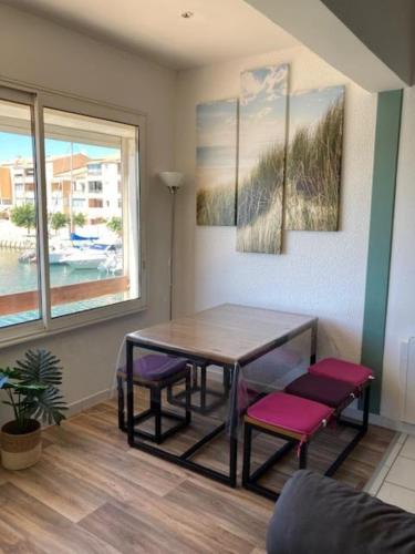 une salle à manger avec une table et des chaises violettes dans l'établissement Duplex apartment facing the port, à Frontignan