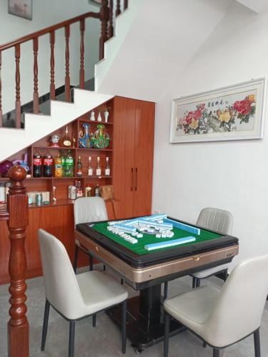 a room with a pool table with chairs and stairs at Jinshanling Great Wall聚友缘民宿 in Gubeikou