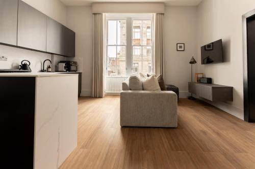 a living room with a couch and a kitchen at Moment Blythswood St in Glasgow