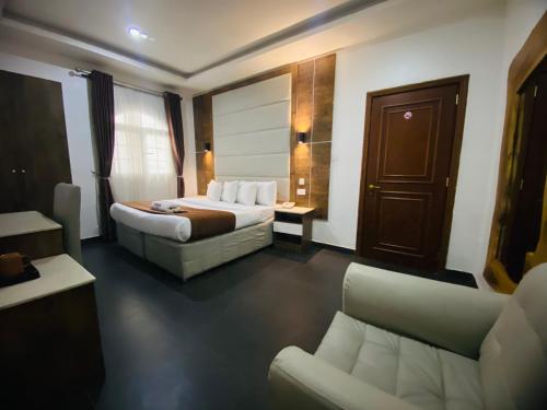 a hotel room with a bed and a couch at PRESKEN WHITE HOUSE in Lagos