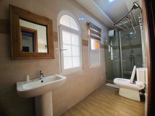 a bathroom with a sink and a toilet at PRESKEN WHITE HOUSE in Lagos