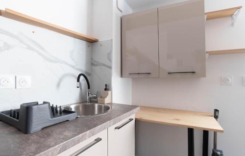 a kitchen with a sink and white cabinets at Studio Coeur De Ville in Solliès-Pont