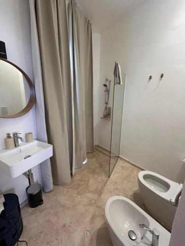 a bathroom with a sink and a toilet and a shower at Libertà Home in Trapani