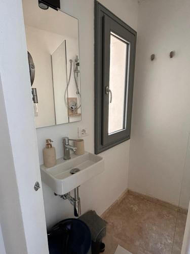 a bathroom with a sink and a mirror at Libertà Home in Trapani