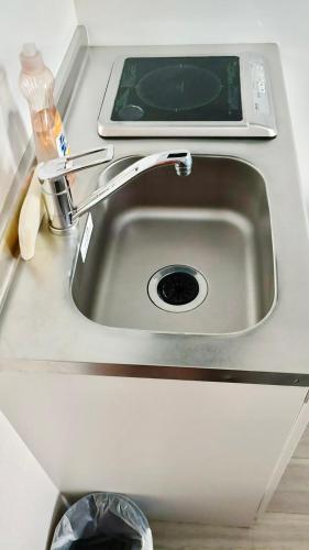 un fregadero con un celular encima en Tokyo West Shinjuku close to Shinjuku Chuo Park, en Tokio