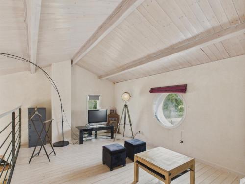 un salon avec une télévision et une table dans l'établissement Maison familiale et colorée avec jardin pour 6, à Saligottière