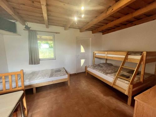 a bedroom with two bunk beds and a window at Márice Vendégház in Siklós