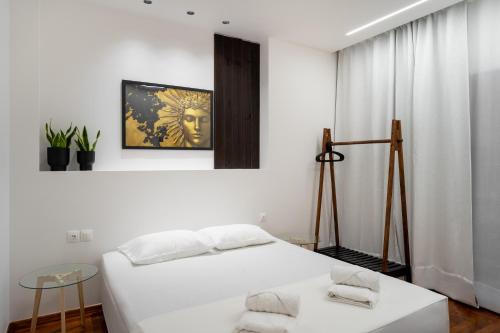a white bedroom with a bed and a window at Magnus Apollo in Thessaloniki
