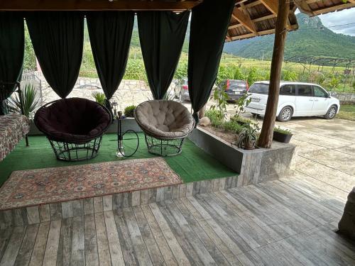 a patio with two chairs and a car in a parking lot at Дом на лоне горы с удобствами и красивым видом на горы и сад in Gandzakʼar
