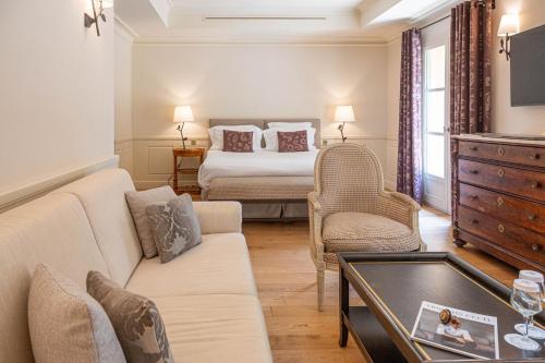 a living room with a couch and a bed at L'Hôtel & Spa du Castellet in Le Castellet