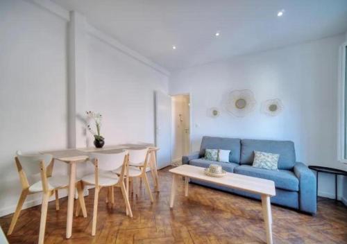 un salon avec une table et un canapé bleu dans l'établissement LOENA CANNES CENTRE - Appartement entier 2 pièces - 4 personnes - proche croisette palais festival plage - internet gratuit - climatisation - non fumeur, à Cannes