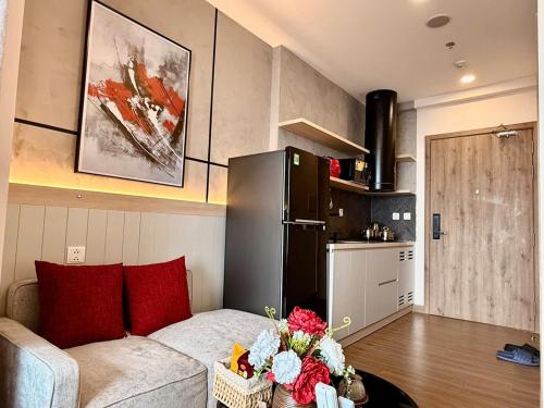 a living room with a couch and a kitchen at Homestay Ecopark Hung Yen by QMP in HÆ°ng YÃªn