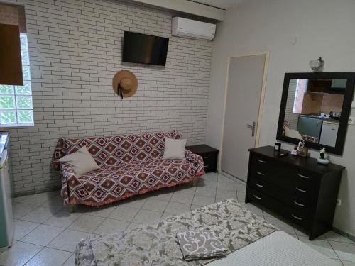 a living room with a couch and a mirror at Vasilis & Nikolas Studios in Limenas