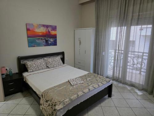 a bedroom with a bed and a large window at Vasilis & Nikolas Studios in Limenas