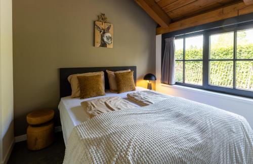 a bedroom with a bed and a window at Landgoed Oud Beekdal in Otterlo