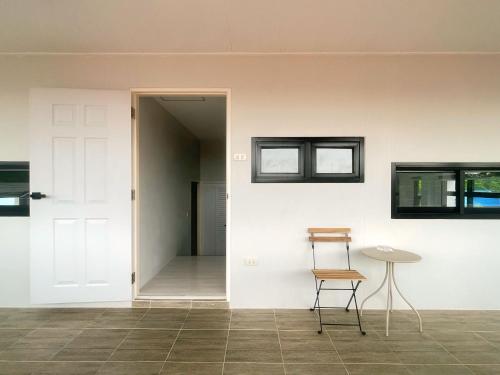 a room with a door and a table and a chair at ใกล้สนามบิน และทะเลสาบ Baan Hug Ubon 3 in Ban Huai Wang Nong