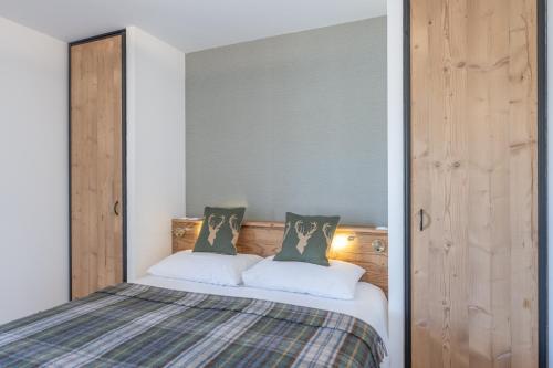 a bedroom with a bed with two pillows at Le Refuge du Pic in L'Alpe-d'Huez