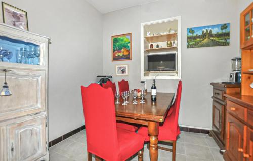 a dining room with a table and red chairs at 2 Bedroom Nice Home In Port Vendres - Flp294 in Port-Vendres