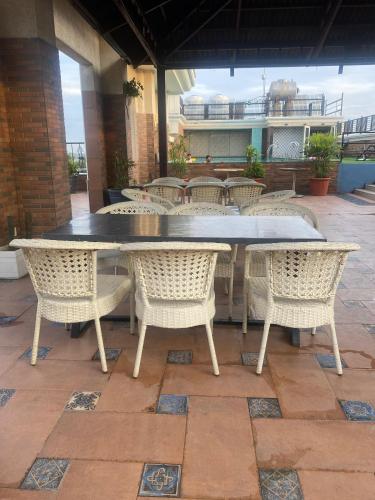a table and chairs sitting on a patio at Hotel Wedcaton By Tivoli - Ambala in Ambāla