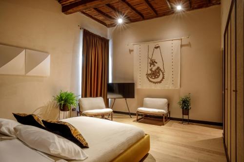 a bedroom with a bed and two chairs and a desk at Daplace - Palazzo Serpe Suites near Colosseum in Rome