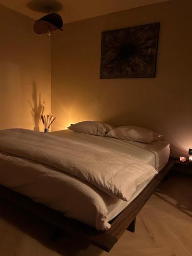a large bed in a bedroom with aigiligiligil at Noma in Gavere