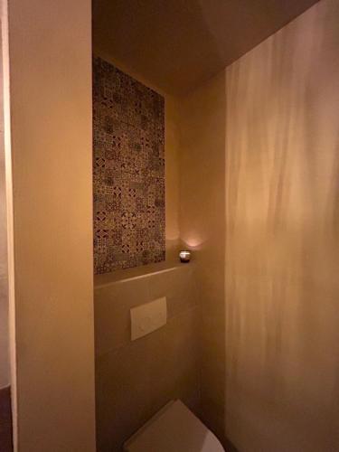 a small bathroom with a toilet and a wall at Noma in Gavere