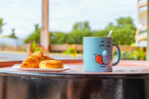 a coffee cup and a plate of bread on a table at greet Hotel Belleville en Beaujolais A6 in Belleville-sur-Saône