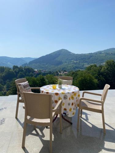 a table and chairs on a patio with mountains in the background at Villa Queen in Visoko