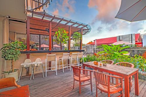 a patio with a bar and tables and chairs at Palette Signature Hotel in Sanur