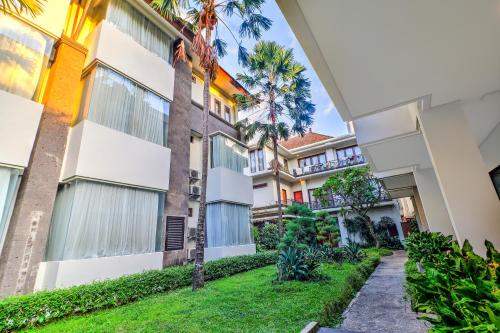 a view of the courtyard of a building with palm trees at Palette Signature Hotel in Sanur