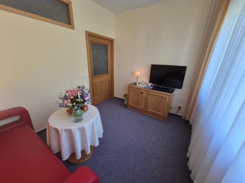 a room with a table with a vase of flowers on it at Panorama Hotel Oberwiesenthal in Kurort Oberwiesenthal