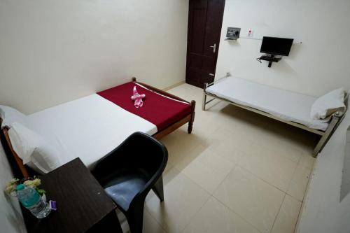 a room with a bed and a table and a chair at Athirappilly Ambady Resort in Athirappilly