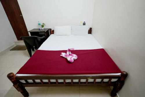 a bedroom with a bed with a pink toy on it at Athirappilly Ambady Resort in Athirappilly