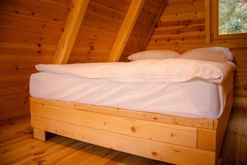 a bed in a wooden room in a cabin at Kućica Hedonija in Donji Sakar