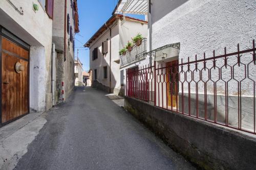 an empty alley with a fence and a building at Welcome Home 2 Meana di Susa in Meana di Susa