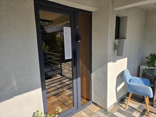a glass door with a blue chair next to a building at Poet Palace Bucharest in Bucharest
