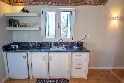 a kitchen with a sink and two windows at Stone residence across Eiffel's Tower - Filiatro 3 in Filiatra