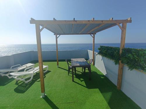 a gazebo with chairs and a table on a balcony at Studio avec terrasse et vue mer in El Escobonal