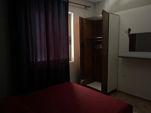 a dark room with a bed and a refrigerator at Ledi’s Home in Borsh