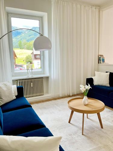 Una sala de estar con un sofá azul y una mesa. en Historische Altbau Suite, en Bad Mitterndorf