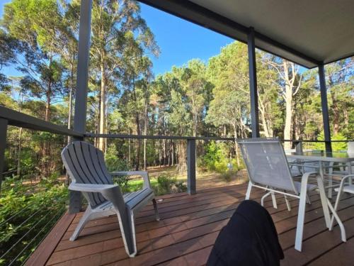 a screened porch with two chairs and a table at 75 Peace Street in Denmark