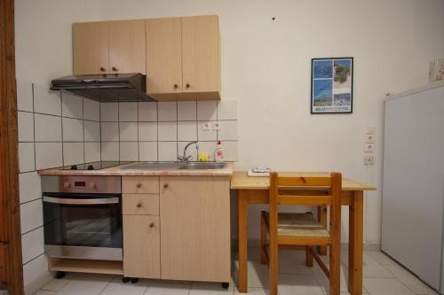 a kitchen with a table and a sink and a stove at Villa Konstantinos in Votsi