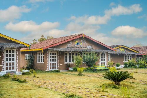a building with a grass yard in front of it at WOW STAYZ2 Pachmarhi Foothill Cottages in Pachmarhī