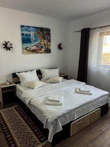 a bedroom with a large bed with two towels on it at Pensiunea Salcioara in Salcioara
